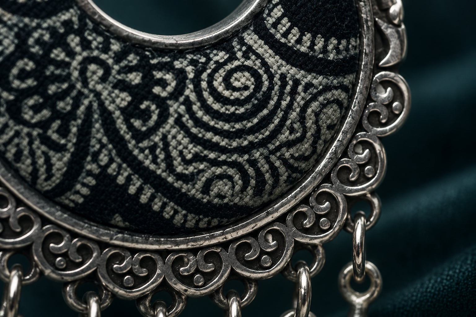 Close detail of batik textile meeting a sculpted Miao silver edge