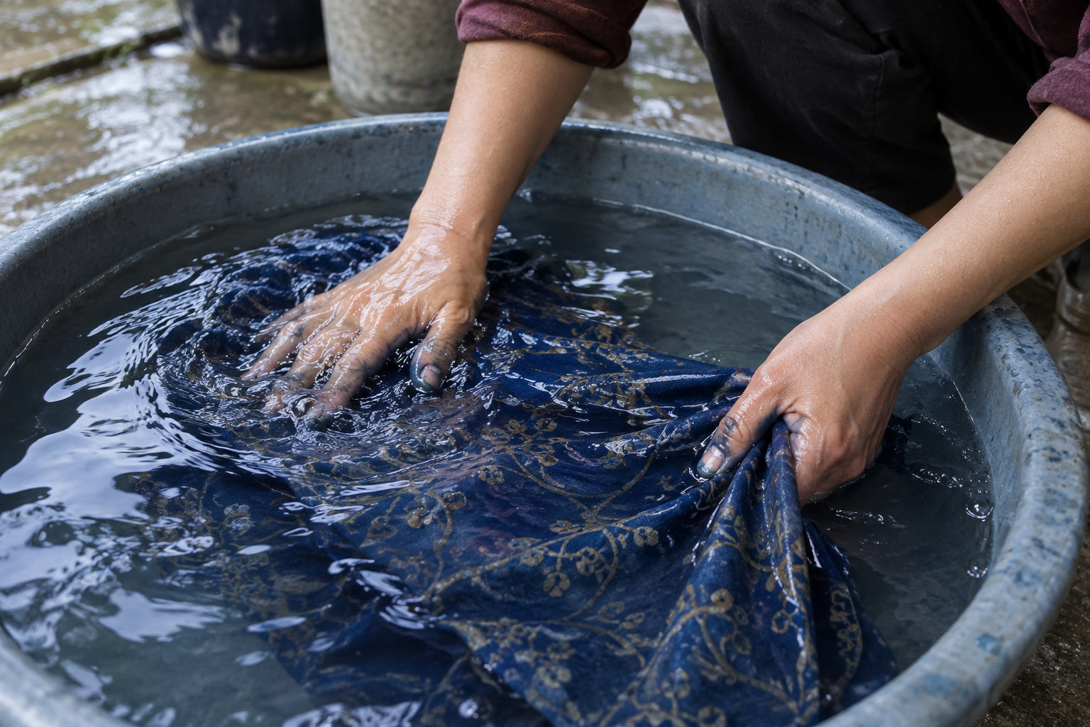 Illustration of dyed cotton being rinsed in cool water before the wax is removed